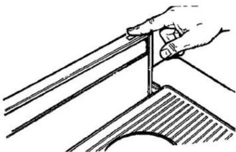 Hand holding a metal angle with a hatched base (no text or symbols)