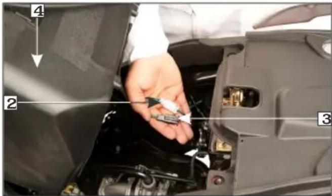 Close-up of a car engine bay with numbered annotations pointing to components like switch, battery, and valve parts.