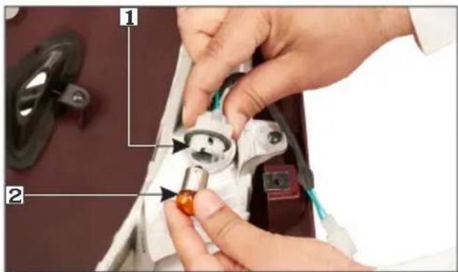 Close-up of hands installing or adjusting a component with numbered annotations pointing to parts 1 and 2.