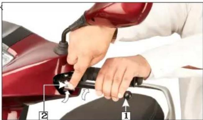 Person refueling a red scooter with labeled parts 1 and 2, showing hand positioning and valve mechanism