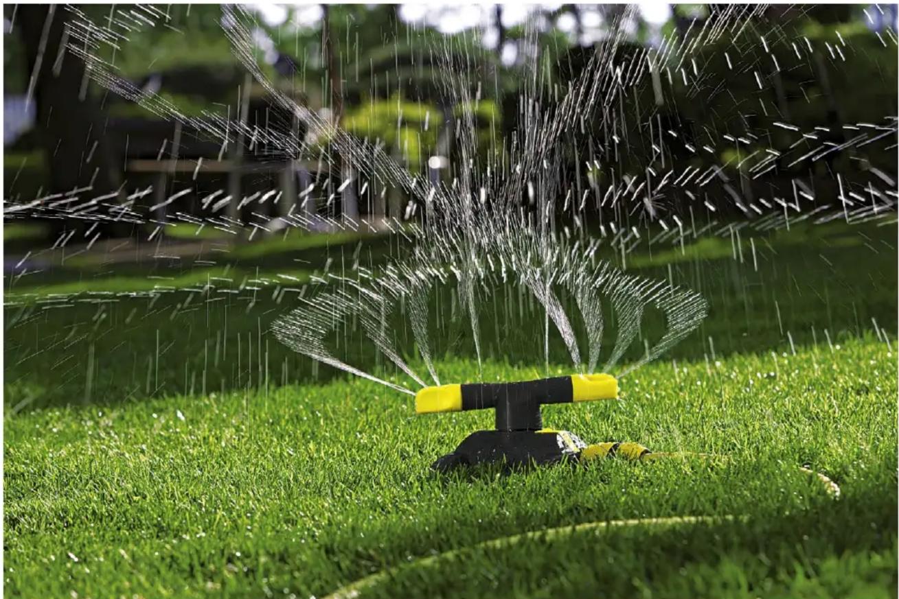 A spray sprayer on a grassy field, spraying water with no visible text or symbols.