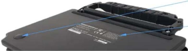 Close-up of a black electronic device casing with blue alignment lines and certification marks (no readable text or symbols)