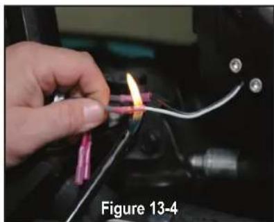 Close-up of a hand holding a small pink component with a flame, connected to wires and a black connector (no visible text or symbols)