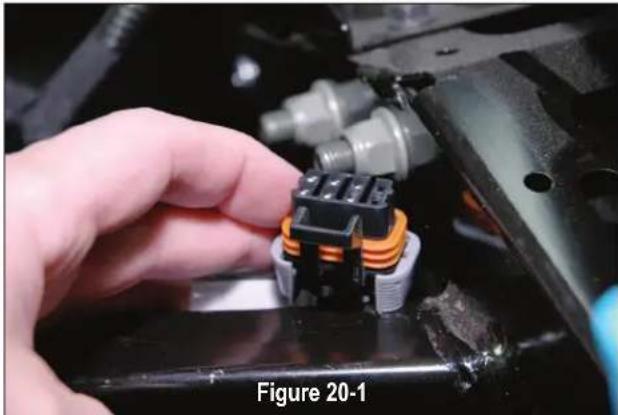 Close-up of a hand adjusting a mechanical component with orange and black components (no visible text or symbols)