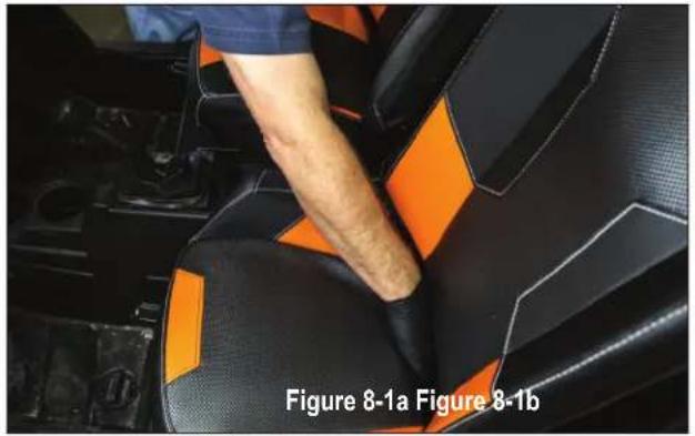 Interior view of a car seat with black and orange patterned seating, showing a person's arm and seatbelt (no text or symbols visible)
