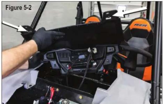 Close-up of a person adjusting a black electronic device with visible wiring and components, labeled Figure 5-2 (no readable text or symbols)