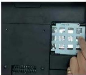 Close-up of a laptop keyboard with a hand interacting with the screen, showing Chinese characters and icons on the keys.