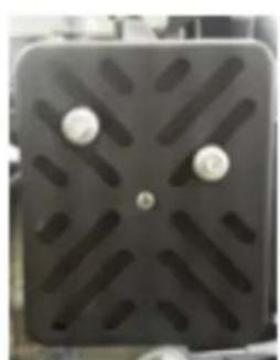 Close-up of a black rectangular electronic component with four metallic pins and a central hole (no visible text or symbols)