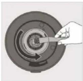 Hand holding a tool interacting with a circular mechanical component (no text or symbols visible)