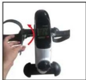 Hand holding a black exercise machine with a red arrow indicating rotation (no visible text or symbols)