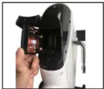 Hand holding a small object inside a white electric device with black casing (no visible text or symbols)
