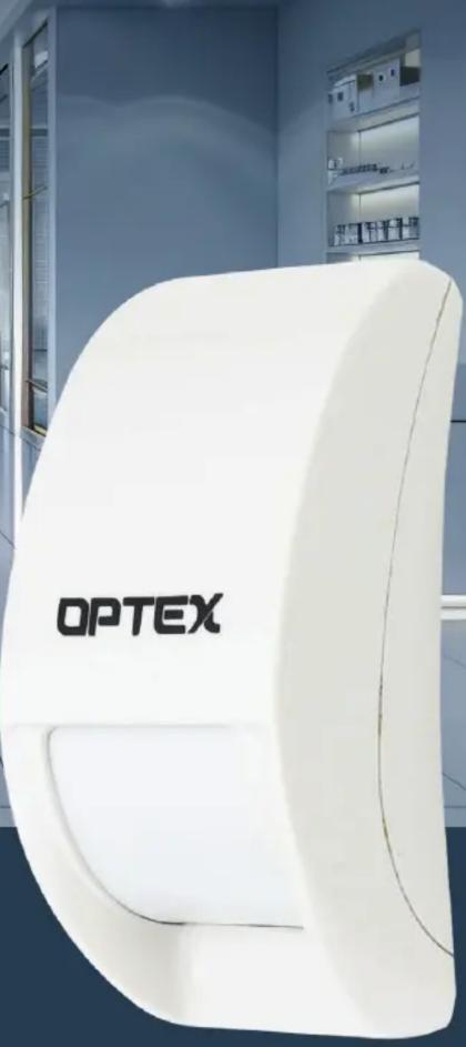 White OPTEX medical device with a curved display stand, displayed in a clinical setting (no visible text or symbols on the device itself)