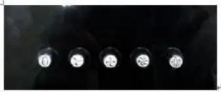 Close-up of four metallic circular components with white centers, arranged vertically against a dark background (no text or symbols visible)