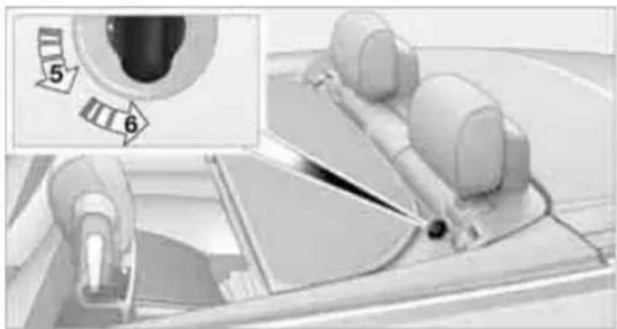 Medical procedure image showing a hand operating a device with an inset close-up of a device component (no visible text or symbols)