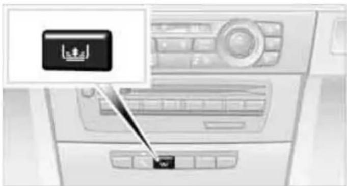 Interior view of a car air conditioner unit with a black control panel and a small icon (no text or symbols visible)