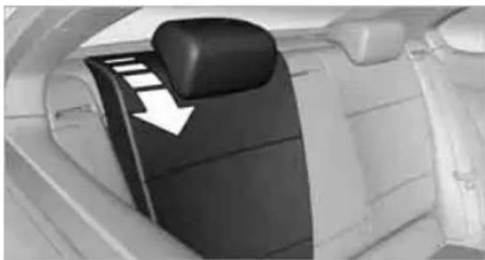 Interior view of a car showing the rear air intake console with a white arrow pointing to the control panel (no text or symbols visible)