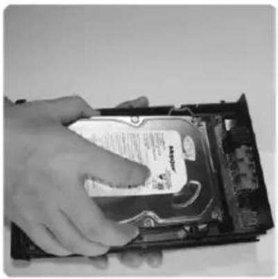 Hand inserting a CD into a hard drive chassis (no visible text or symbols)