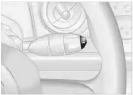 Close-up of a car interior showing the hand holding a small electronic device (no visible text or symbols)