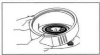 Illustration of hands holding a circular device with a central knob (no text or symbols visible)