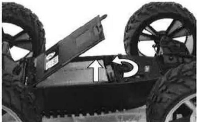 Close-up of a tracked vehicle with two large tires and an open chassis, showing mechanical components and motion arrows (no text or symbols)