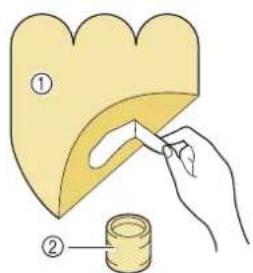 Illustration showing a hand holding a yellow heart-shaped object with a tool, and a small container with a label indicating two steps.