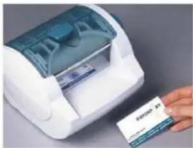 Photo of a hand inserting a card into a white scanner, with visible brand name 'BASCO' on the card.