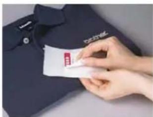 Hand holding a card with visible text and logo, partially visible on a dark shirt