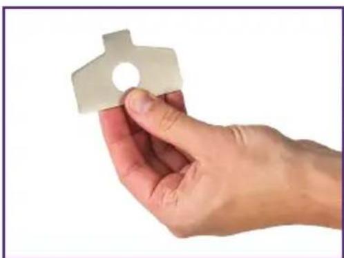Hand holding a small white paper airplane-shaped object against a plain white background (no text or symbols visible)