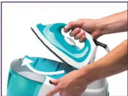Close-up of hands ironing a turquoise and white steam iron (no text or symbols visible)
