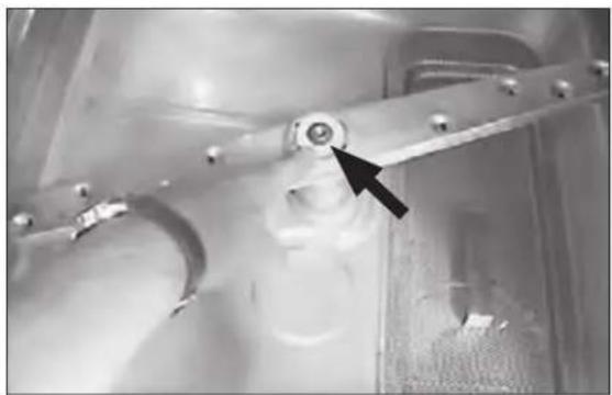 Close-up of a mechanical component with a black arrow pointing to a circular feature (no visible text or symbols)