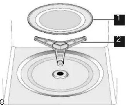 Technical diagram of a mechanical device with labeled parts 1 and 2, showing a central component inserted into a circular base.