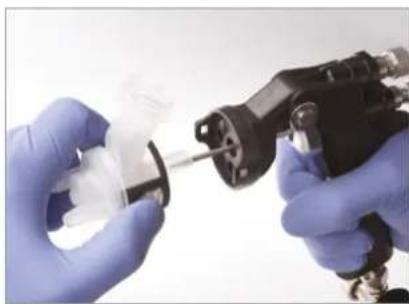 Close-up of gloved hands assembling a mechanical component with a tool (no visible text or symbols)