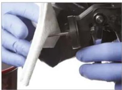 Close-up of gloved hands performing a precision inspection on a mechanical component (no visible text or symbols)