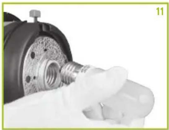 Close-up of a gloved hand holding a mechanical component with threaded screw and bolt (no visible text or symbols)
