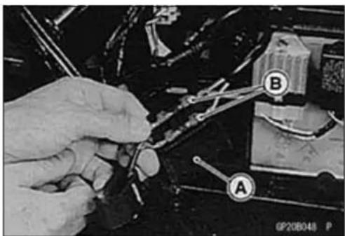Close-up of hands using a tool to adjust or repair components with labeled parts A and B