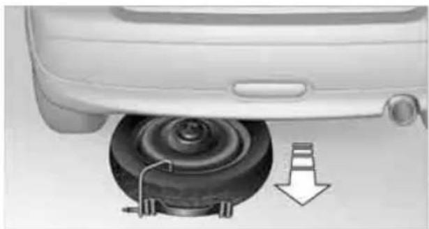 Mechanical component with a circular base and mechanical parts, showing a downward arrow indicating motion (no text or symbols)