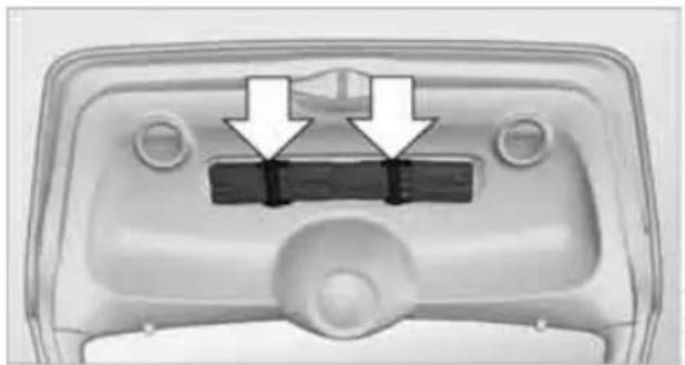 Top-down view of a vehicle front panel with two arrows pointing to a rectangular component (no text or symbols visible)