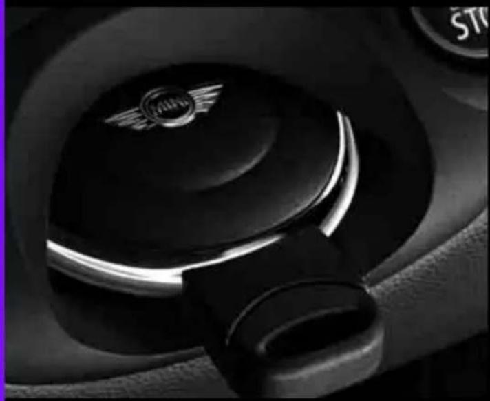 Close-up of a car's seatbelt with a circular emblem on the lid (no visible text or symbols)