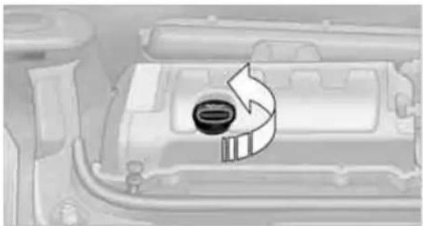 Close-up of a car engine bay with a circular component and directional arrow indicating rotation (no text or symbols)