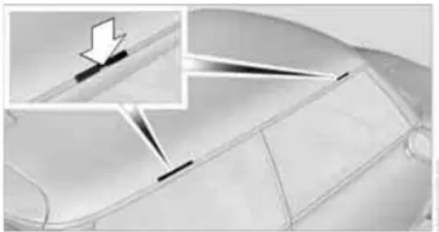 Close-up of a car's side panel with an inset showing a downward arrow and a diagonal line (no text or symbols)