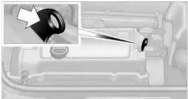 Interior view of a vehicle showing a black key inserted into the dashboard with a white arrow pointing to it (no text or symbols visible)
