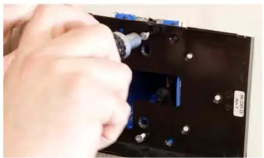 Close-up of hands installing a component into a black electronic device (no visible text or symbols)