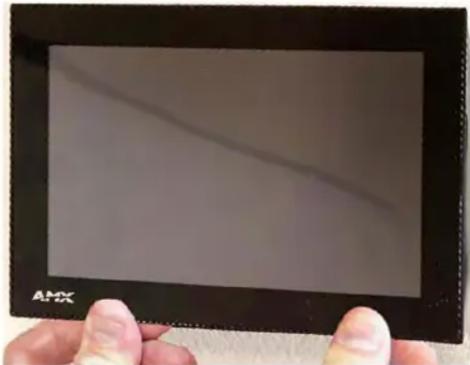 Close-up of a hand holding a black tablet device with a visible diagonal line on its screen (no text or symbols on the device itself)