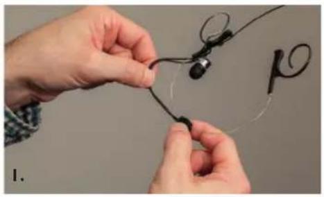 Close-up of hands tying a knot around an earpiece (no text or symbols visible)