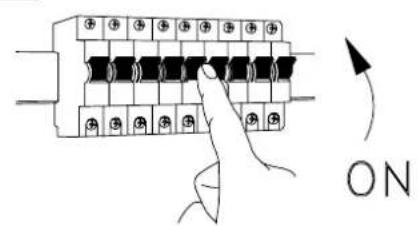 Diagram showing a hand pressing a button on an electrical terminal block with ON/OFF symbols and directional arrow indicating rotation.