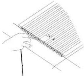 Hand holding a ruler and measuring a surface with diagonal lines (no text or symbols)