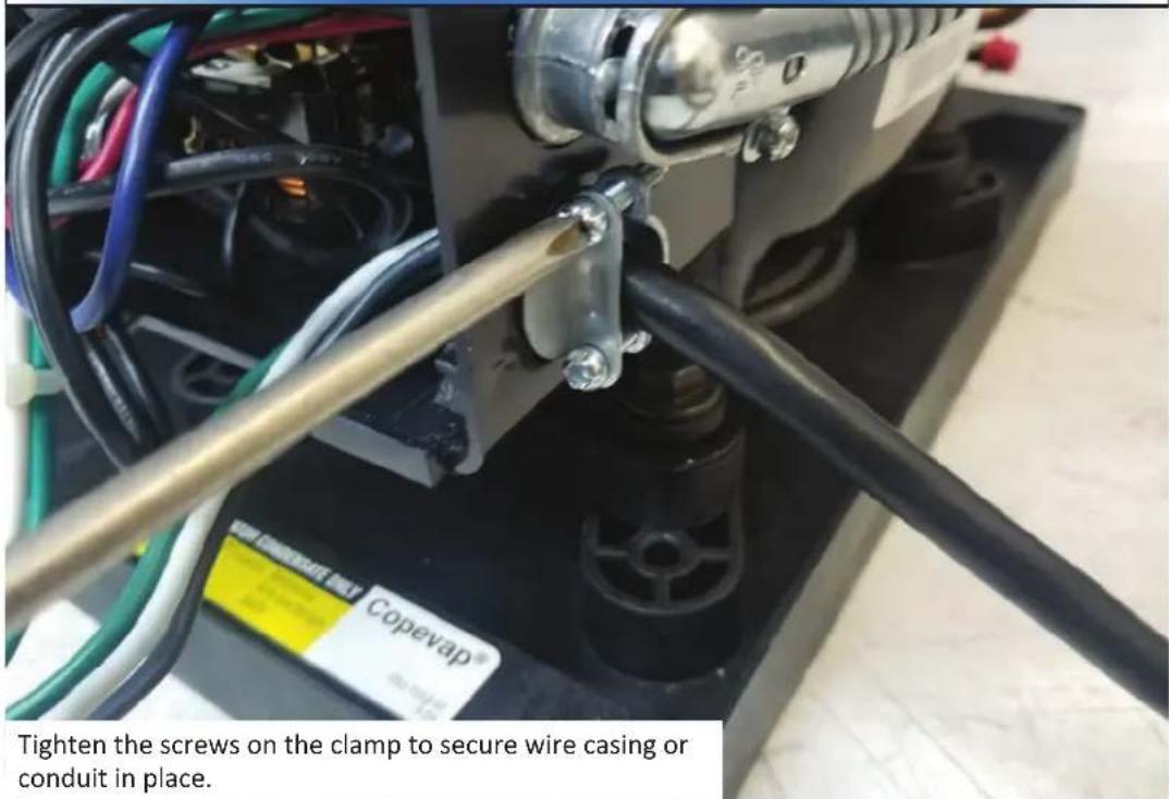 Tighten the screws on the clamp to secure wire casing or conduit in place.