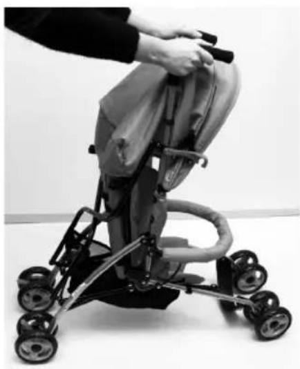 Black-and-white photo of a baby stroller with hands adjusting the seat (no text or symbols visible)