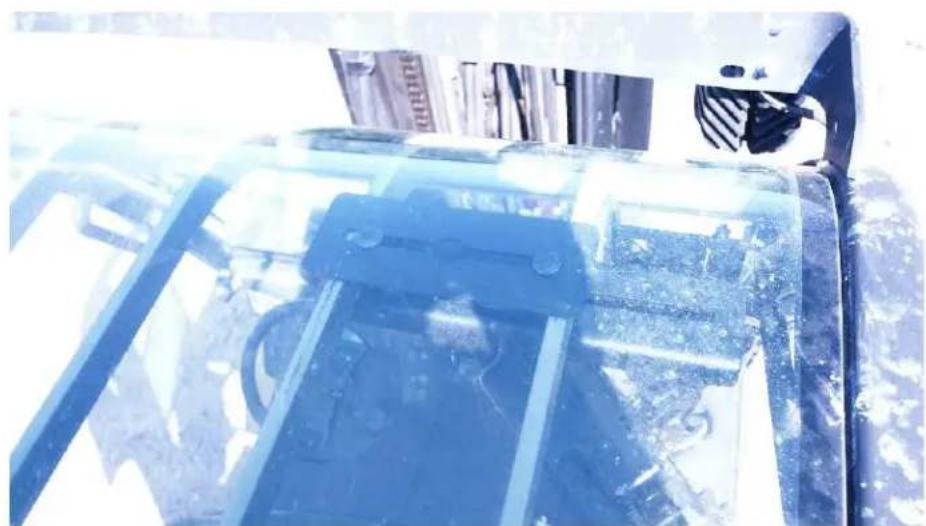 Close-up of a vehicle's roof structure with visible snow and dust, no text or symbols present