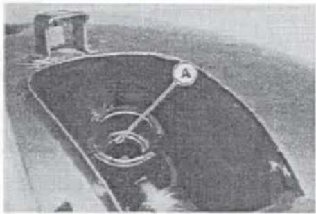 Exterior view of a dark, curved container with a circular label and a handle, no visible text or symbols